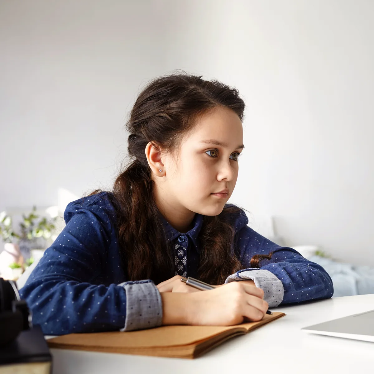 Mädchen schaut aufmerksam auf ihren Laptop