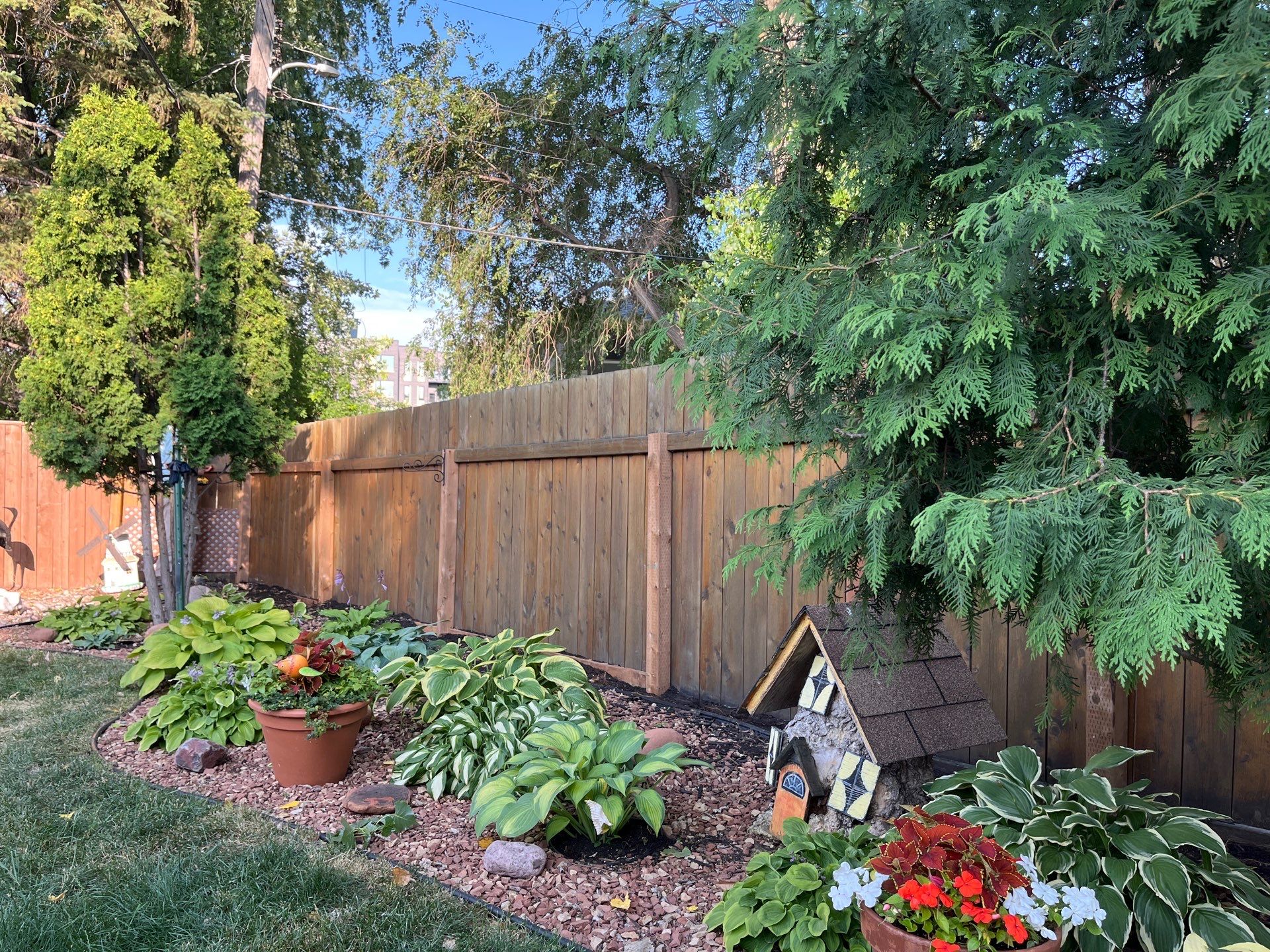 New pressure-treated wooden fence post being installed to straighten a leaning fence.