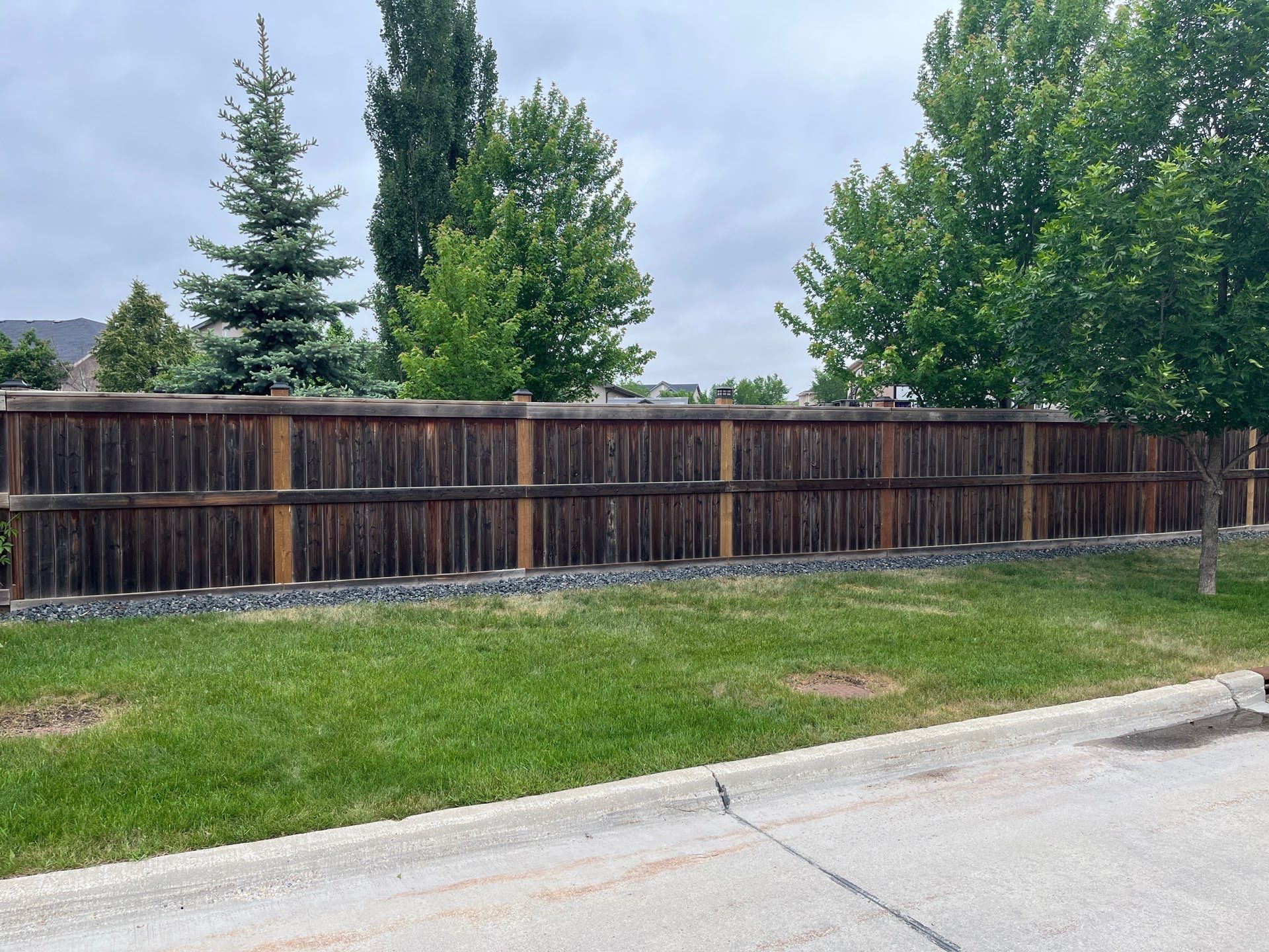 A leaning older fence was repaired by replacing the posts