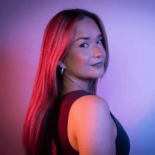 Woman with long hair looking over her shoulder against a gradient purple and pink background.