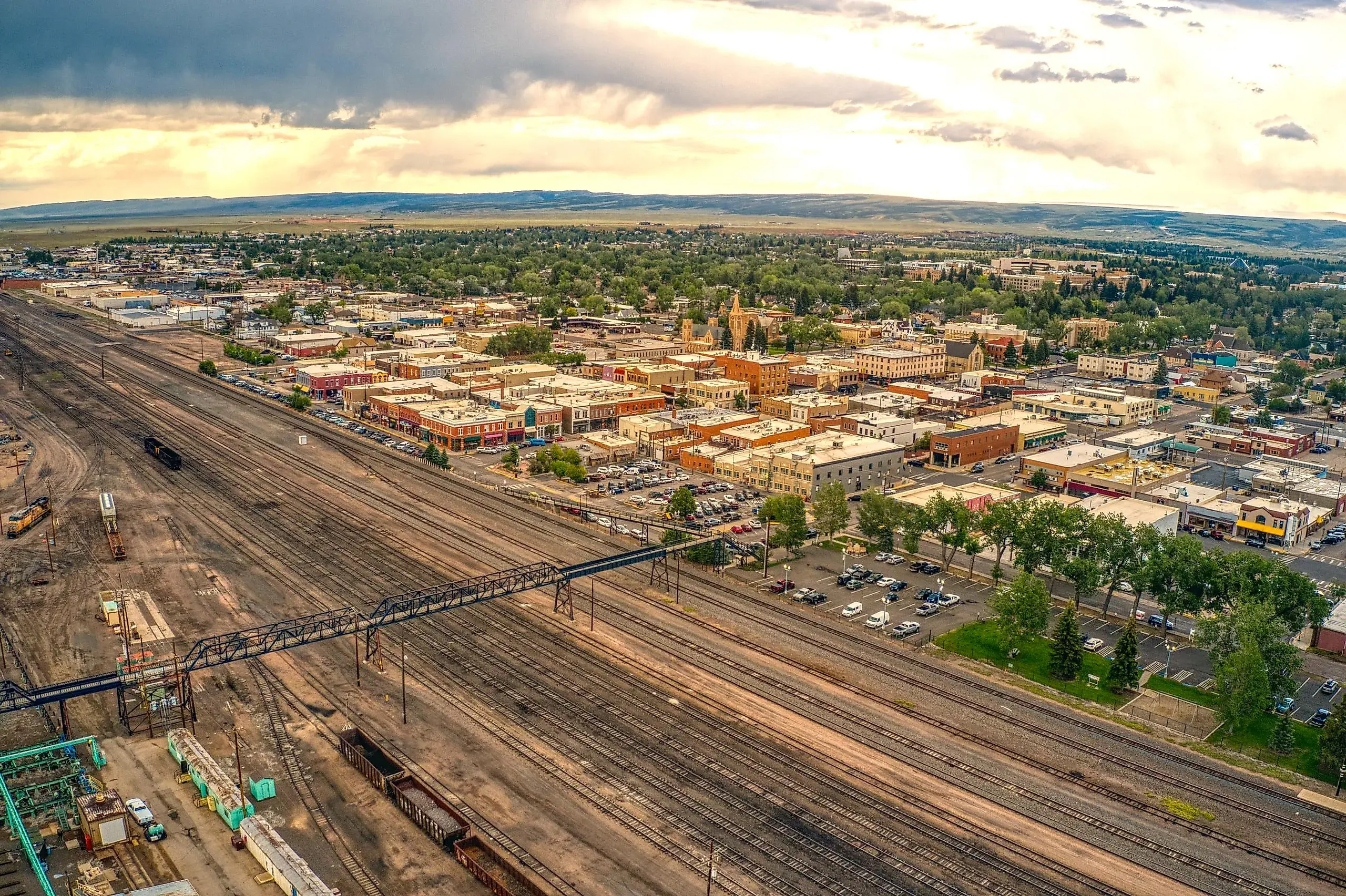 Aerial view of Laramie, Wyoming showing rail yards, streets, and buildings at sunset