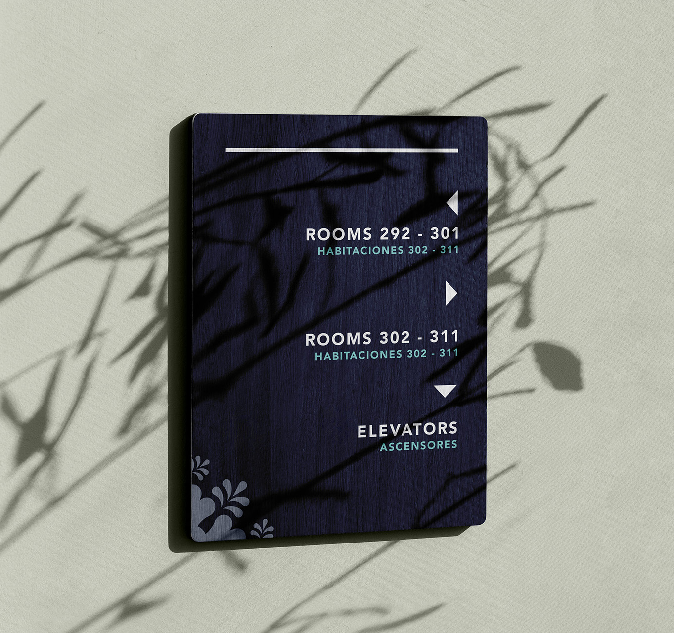 Dark blue directional sign on a light wall showing directions for rooms 292-301 left, rooms 302-311 right, and elevators down.