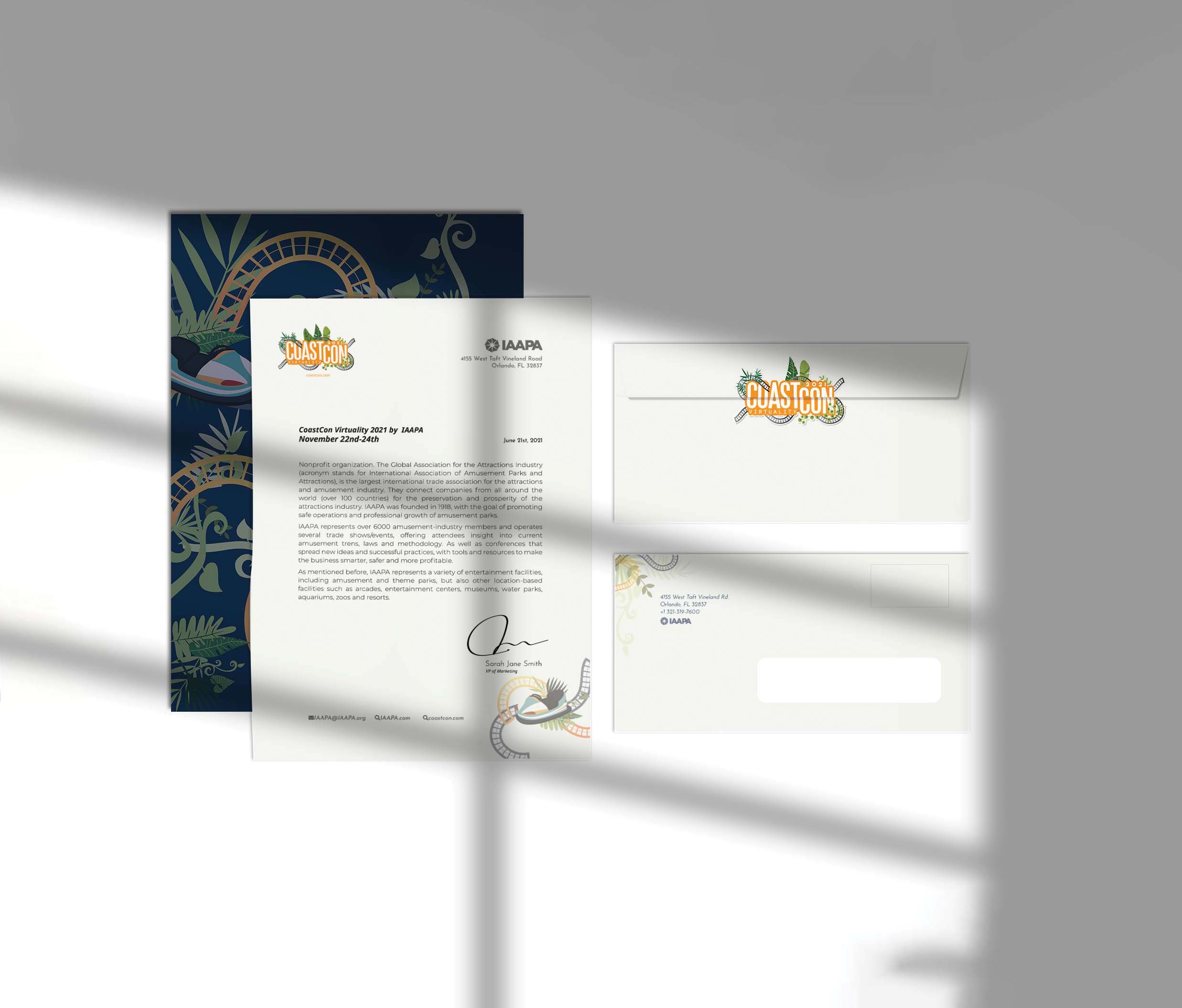 Set of CoastCon branded stationery including a letter, an envelope, and a folder with roller coaster and tropical leaf designs, laid out on a white surface with soft shadows.