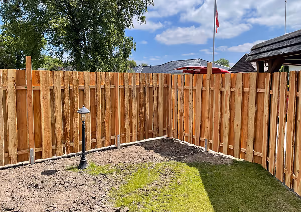 Holzzaun in einem Garten mit einem kleinen Bodenbereich.