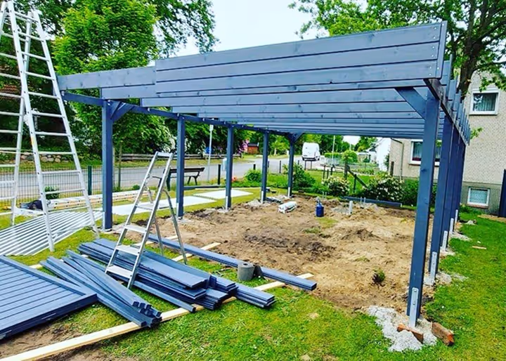 Unvollständige Carport auf einer Baustelle mit Bauholz.
