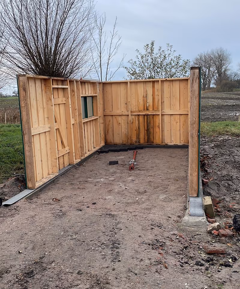 Teilweise errichtetes Gartenhaus mit Sandboden auf einem Baustellenareal .