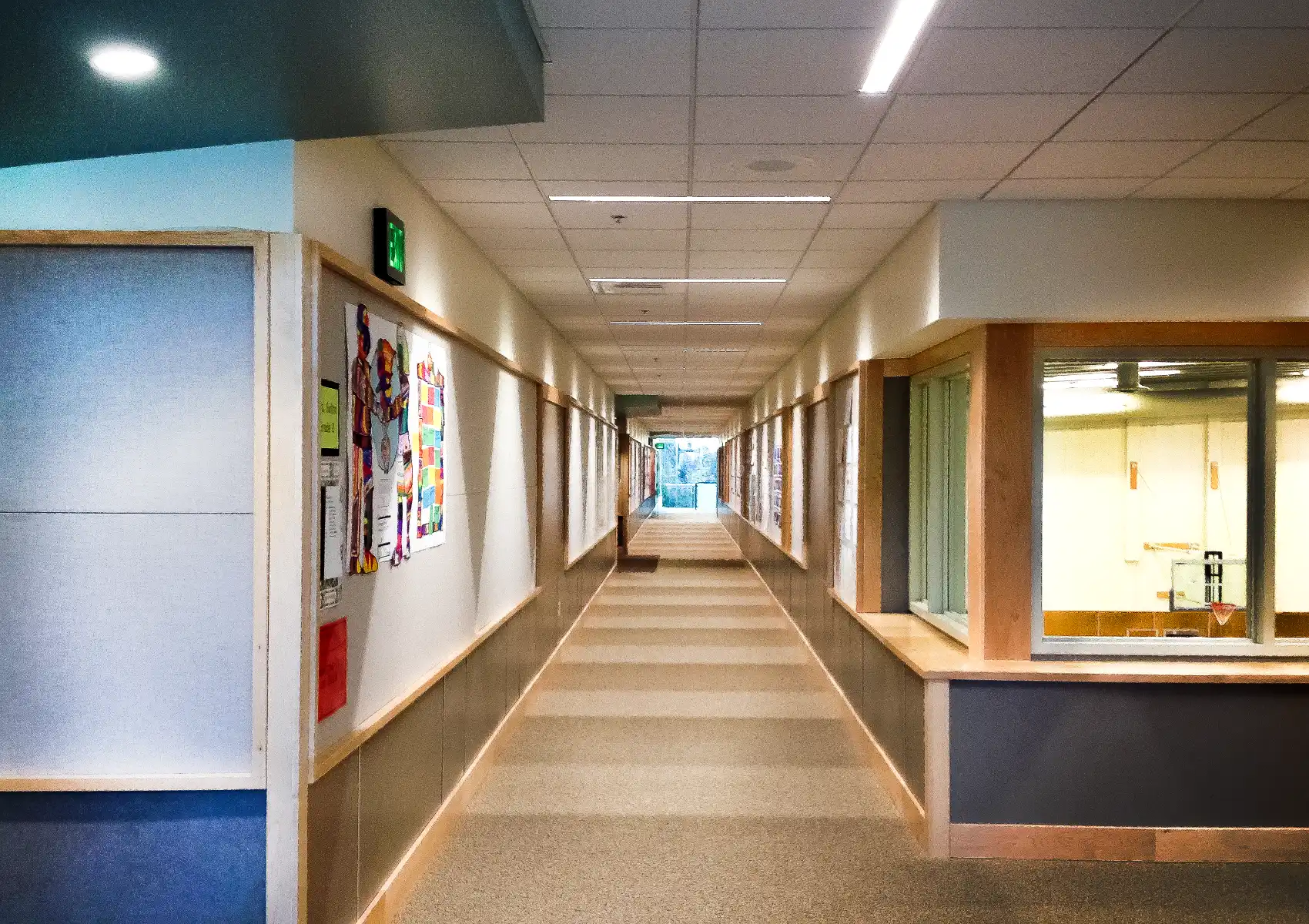 Window at intersecting corridors overlooking the gym below.