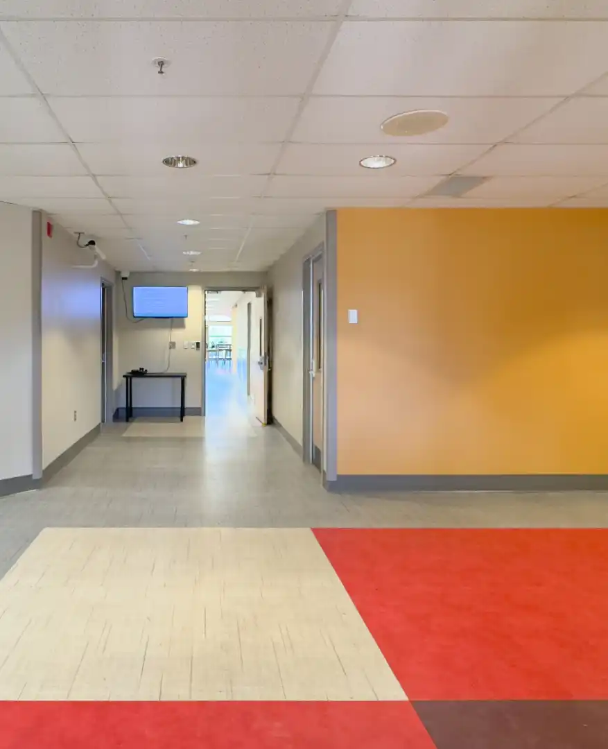 Lobby with yellow wall and colorful grided flooring.