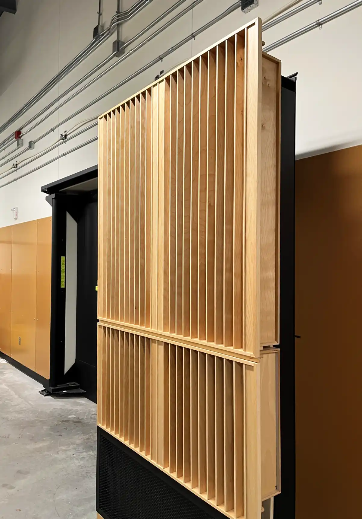 An open hidden door showing it's frame and built-in acoustical diffusers.