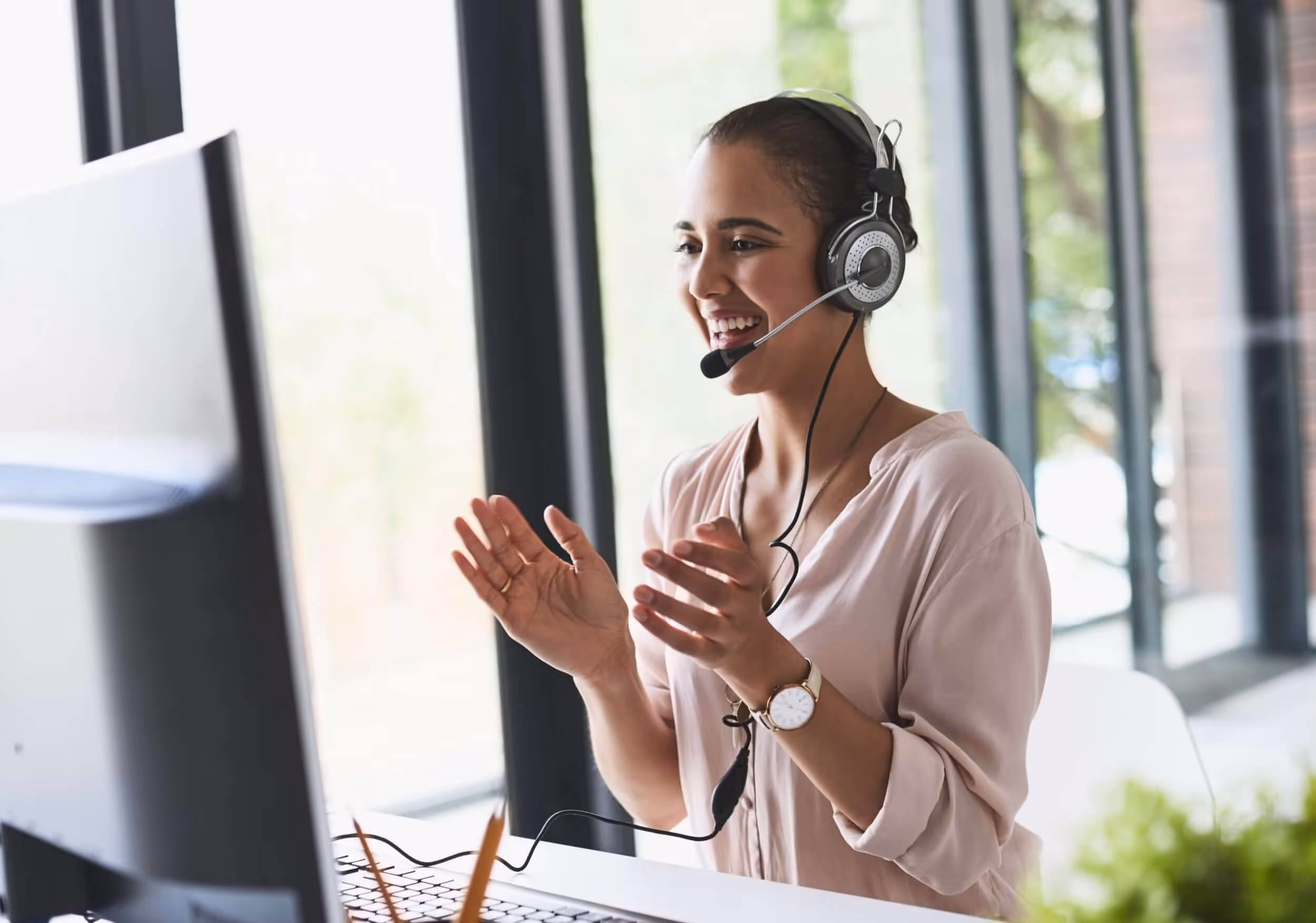 Three children lying on a bed, smiling and looking at a laptop screen together.