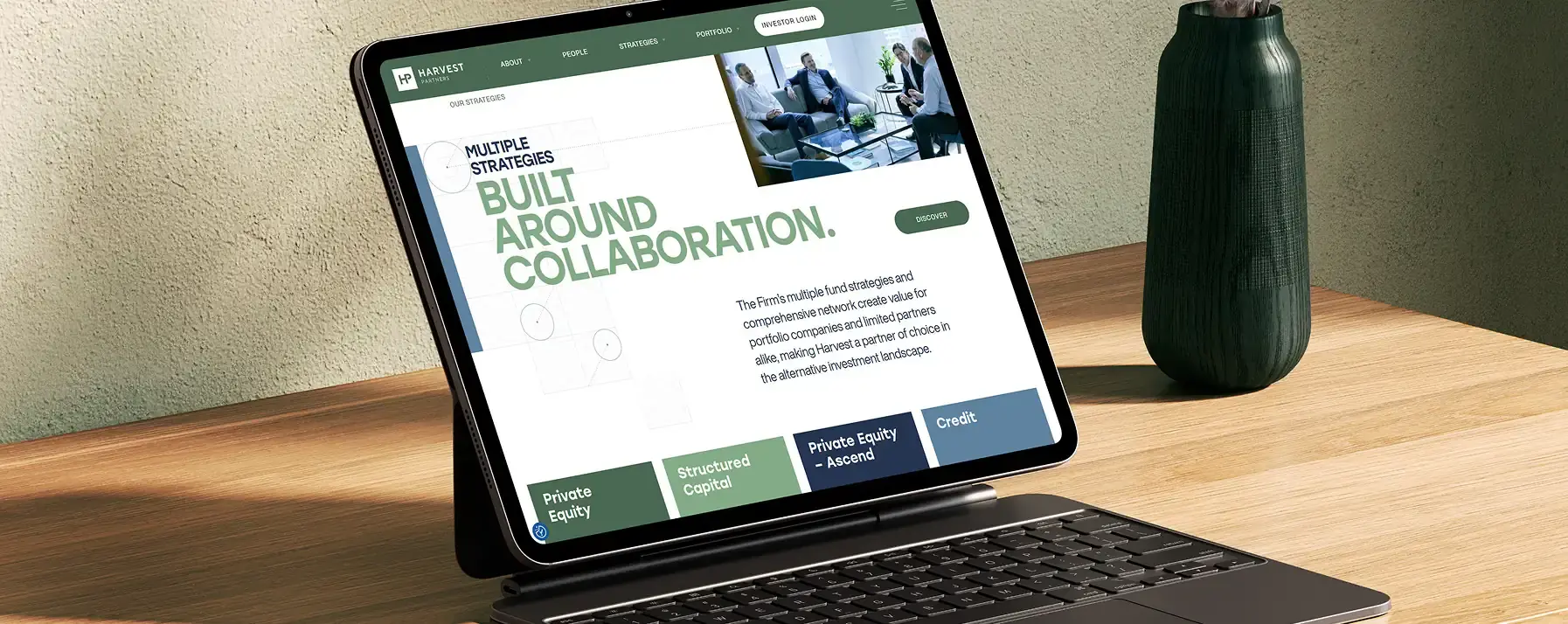 A private equity website design by Darien Group opened on a tablet on a wooden table.