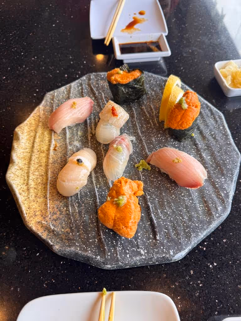 A plate of sushi with a lemon wedge on top.