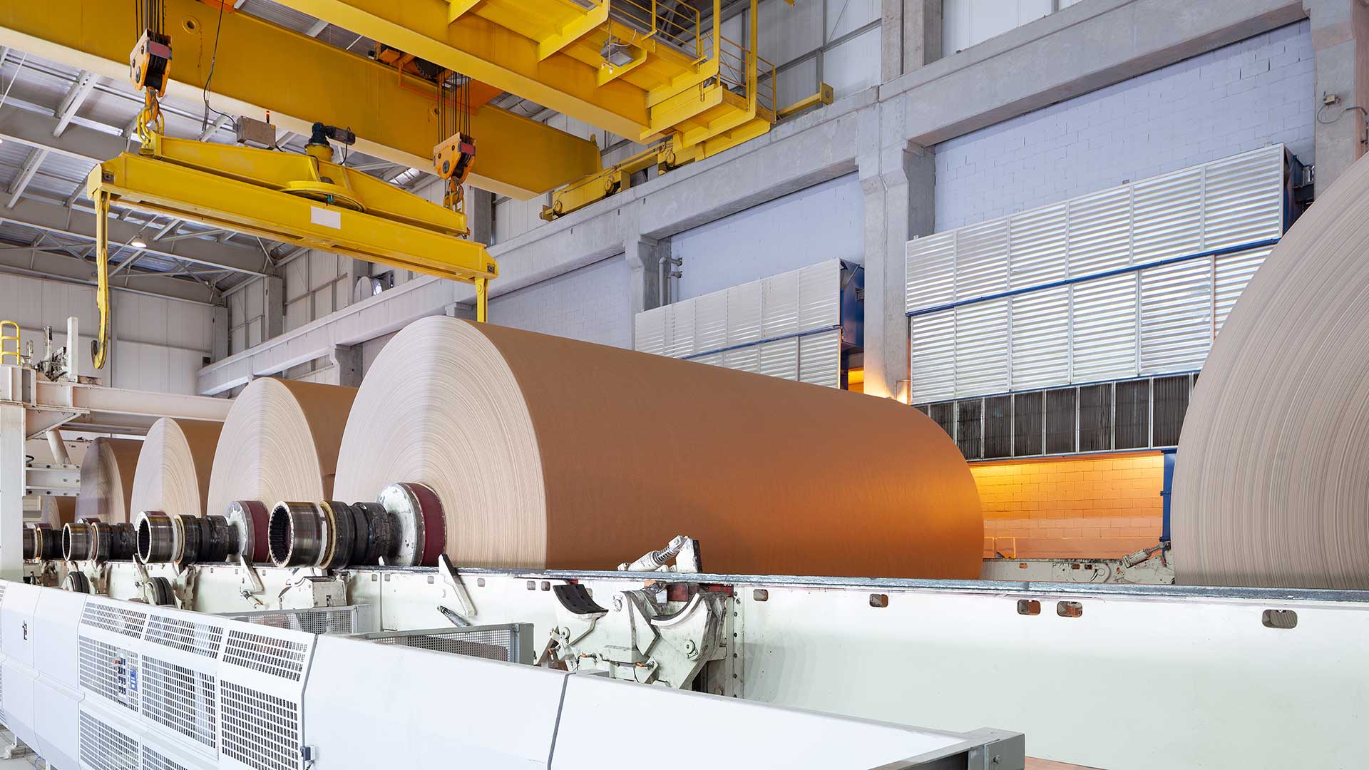 Large brown paper rolls on industrial winding line