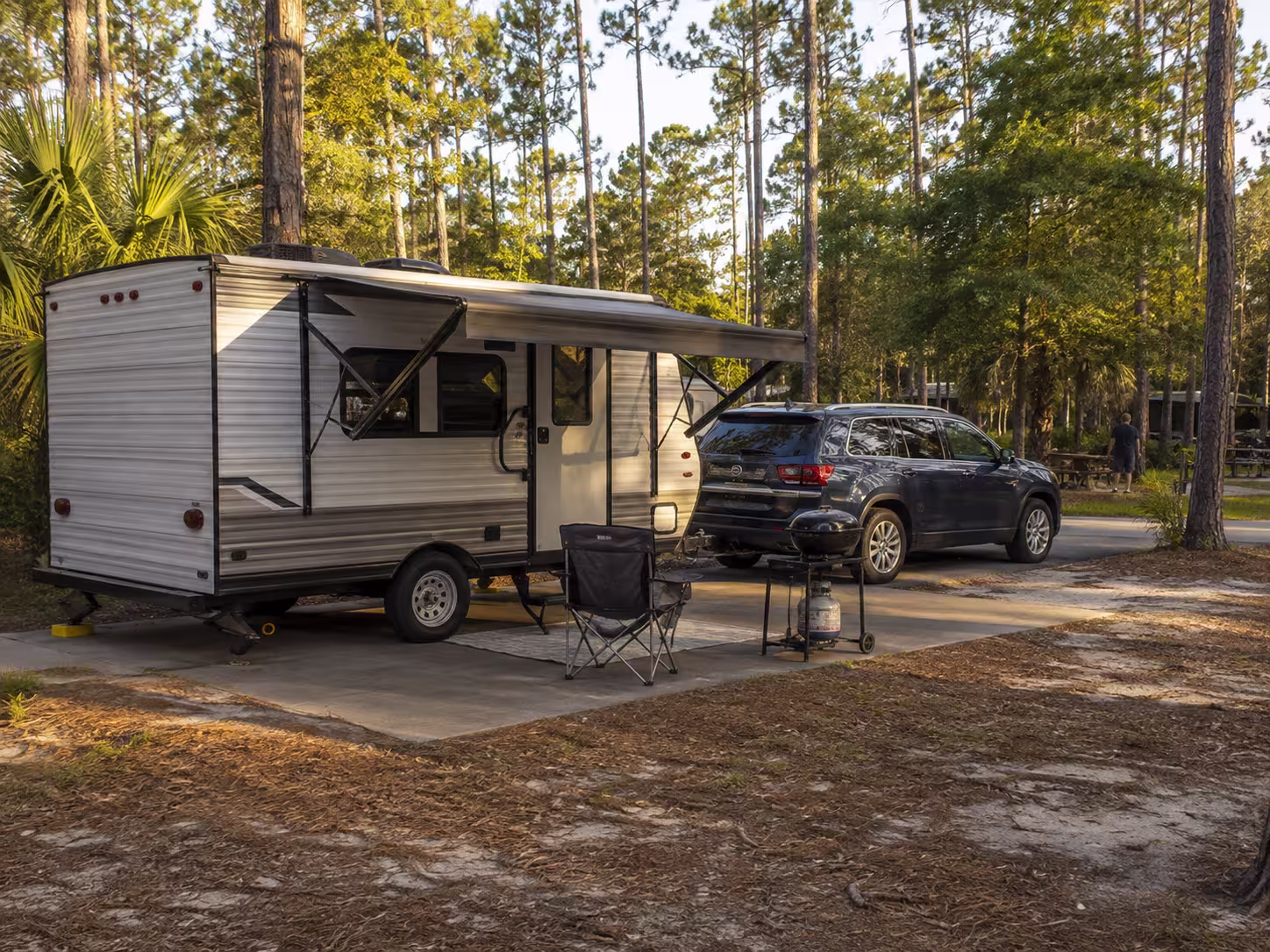 Small travel trailer rental towed by an SUV near Orlando