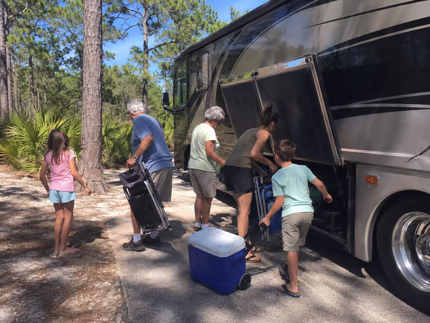 Family unloading gear from a Class A motorhome rental in Florida