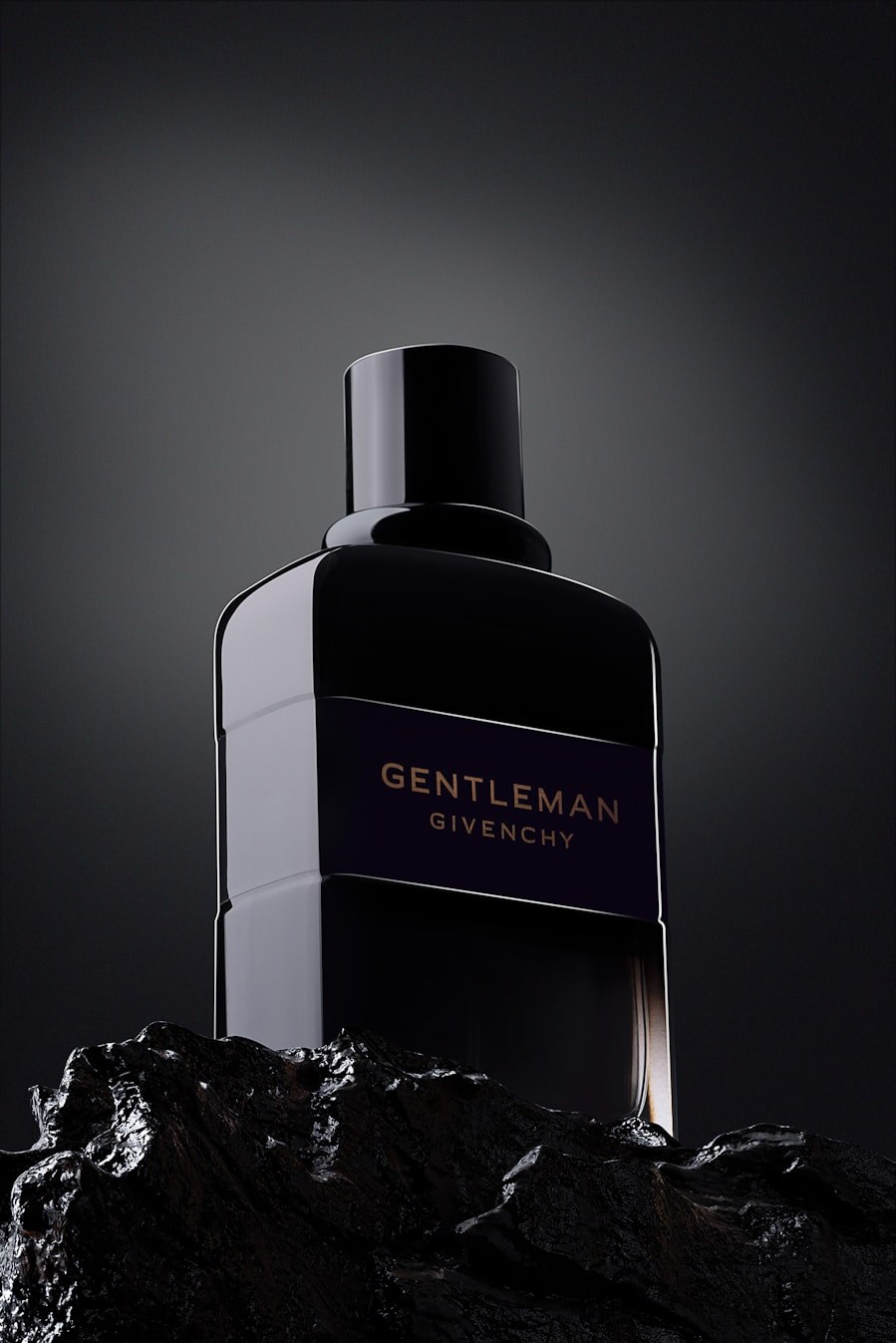 Dark glass fragrance bottle standing on textured rock