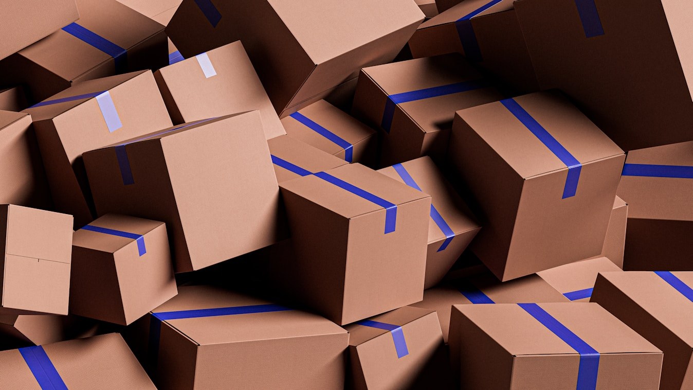 Stack of kraft shipping cartons sealed with blue tape