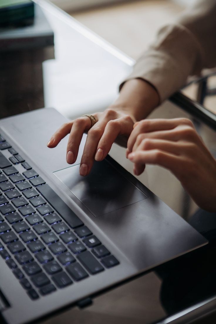 Hands typing on a laptop keyboard