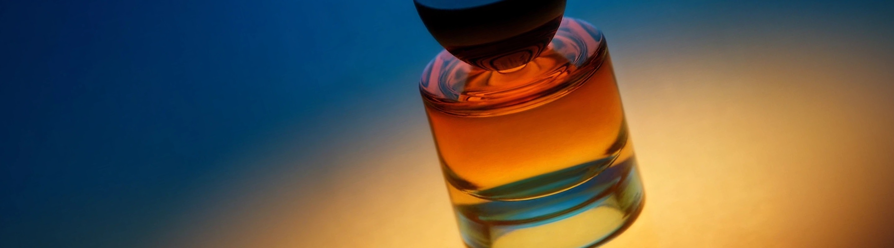 Amber glass fragrance bottle lit by warm light