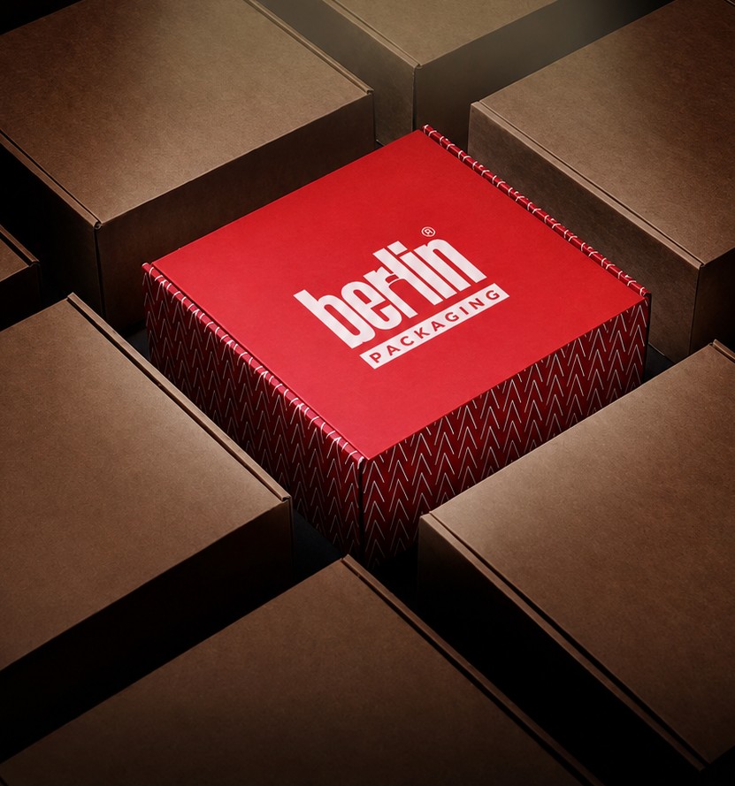 Red Berlin Packaging box spotlit on a grid of kraft cartons
