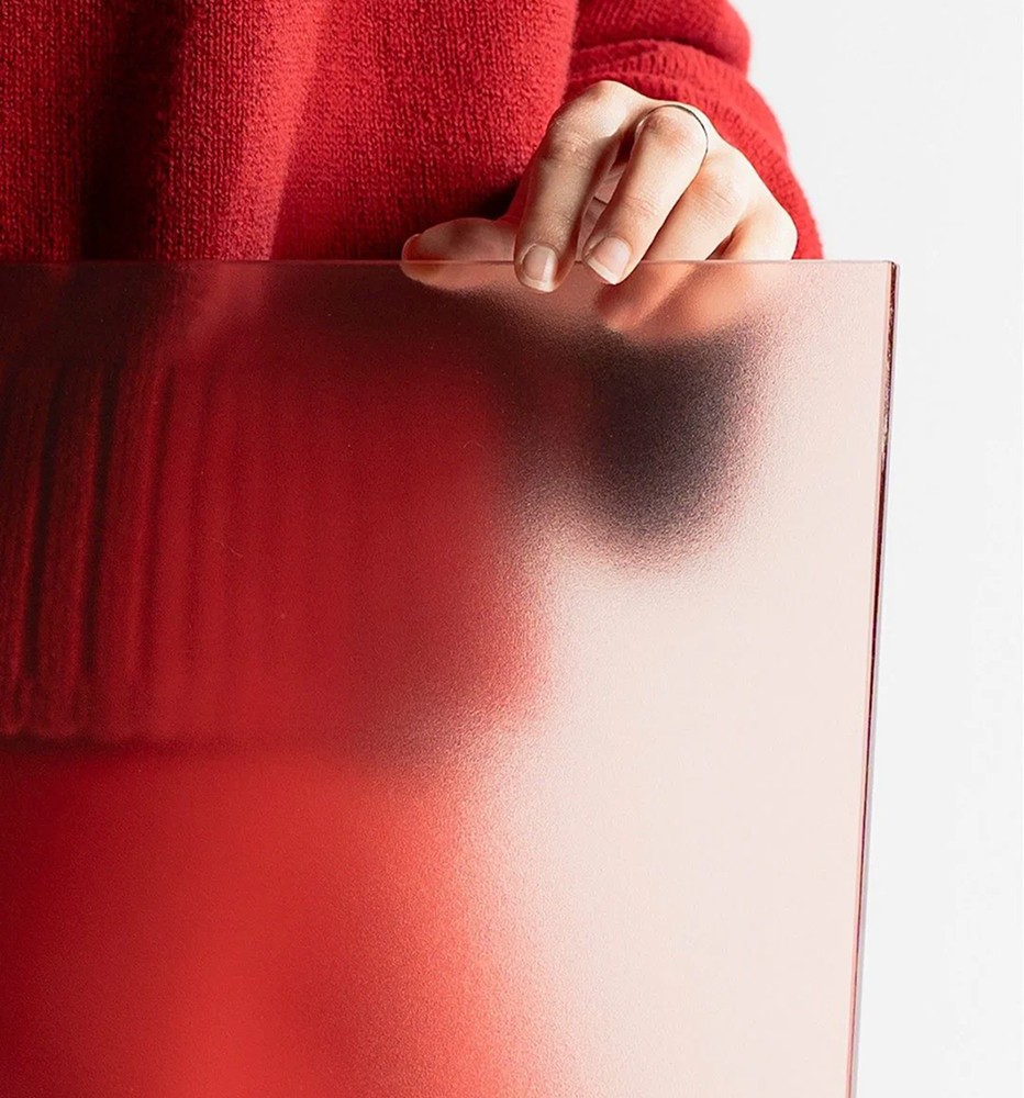 Hand in a red sleeve resting on a frosted red package
