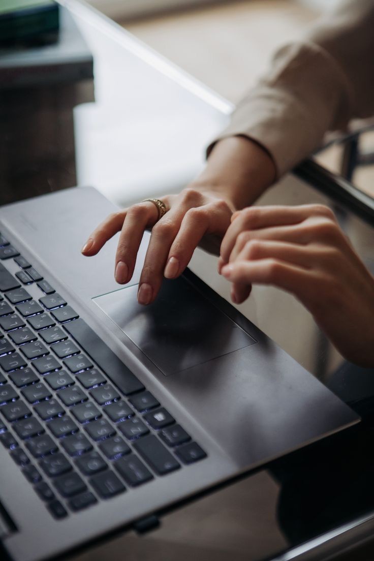 Hands typing on a laptop keyboard