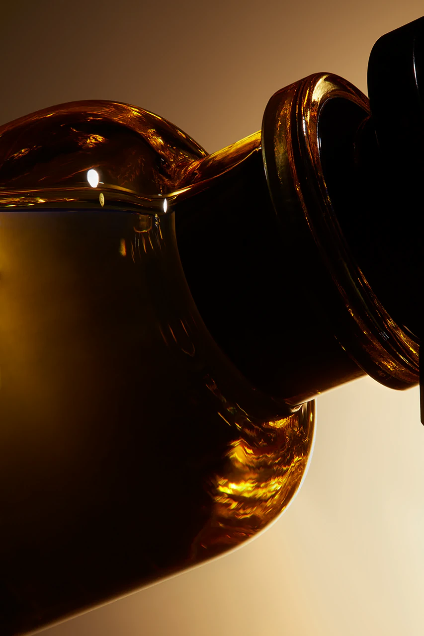 Amber glass bottle pouring in warm backlight