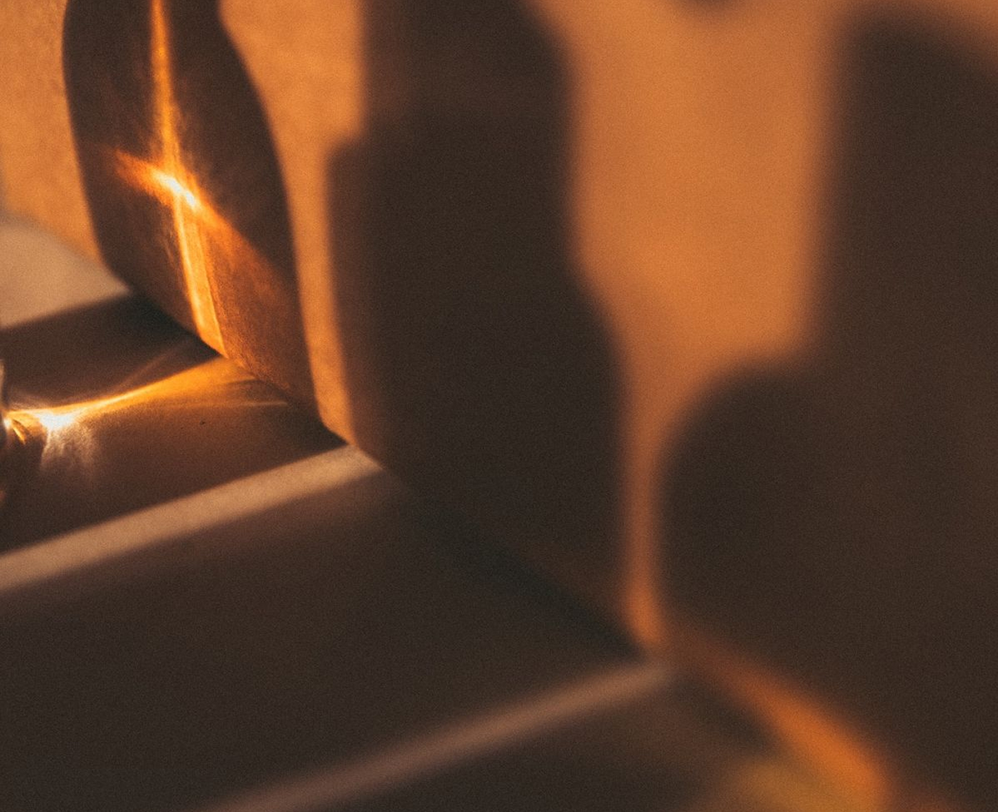 Warm amber light falling across a studio still life of packaging