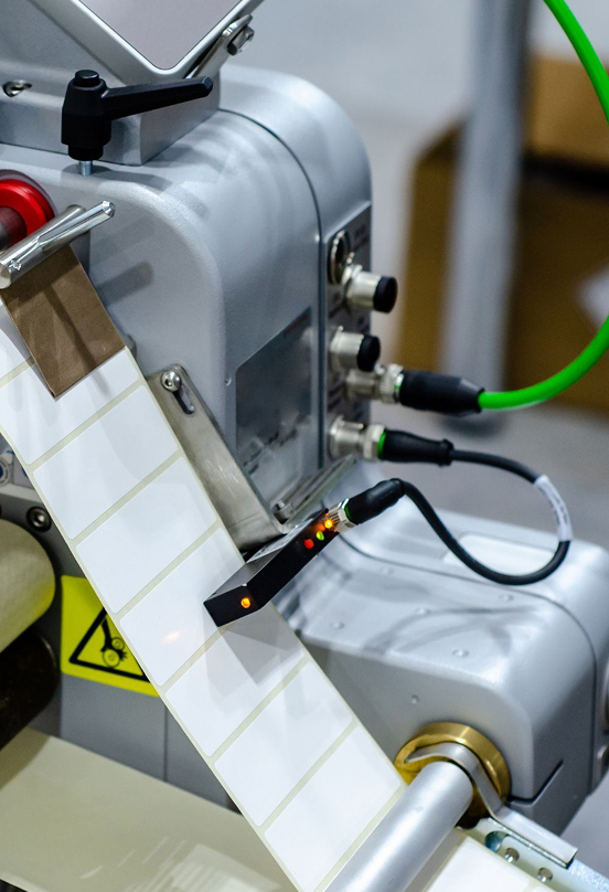 Automated labeling head applying a label to a container