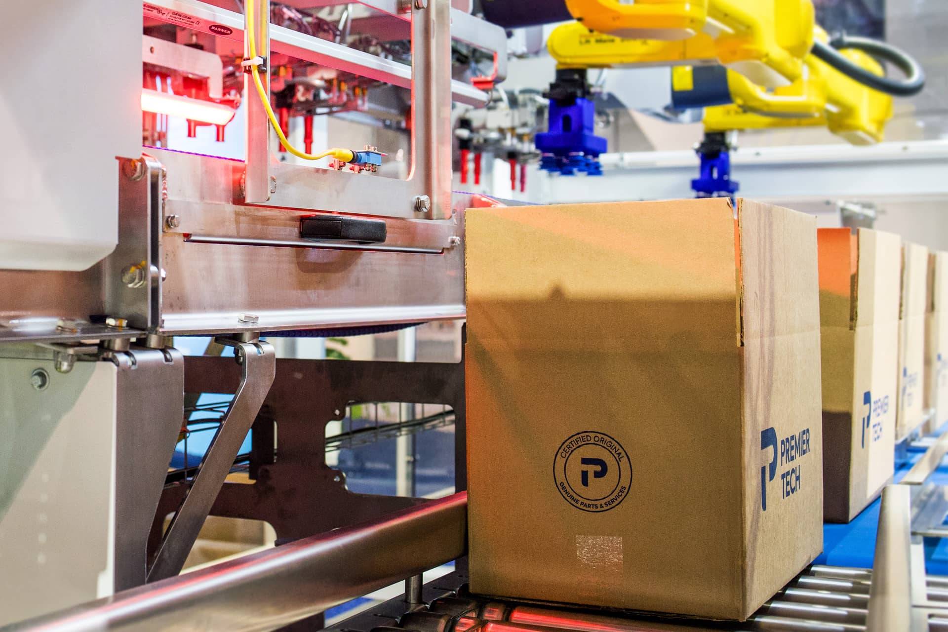 Red case packer loading cartons at the end of a packaging line