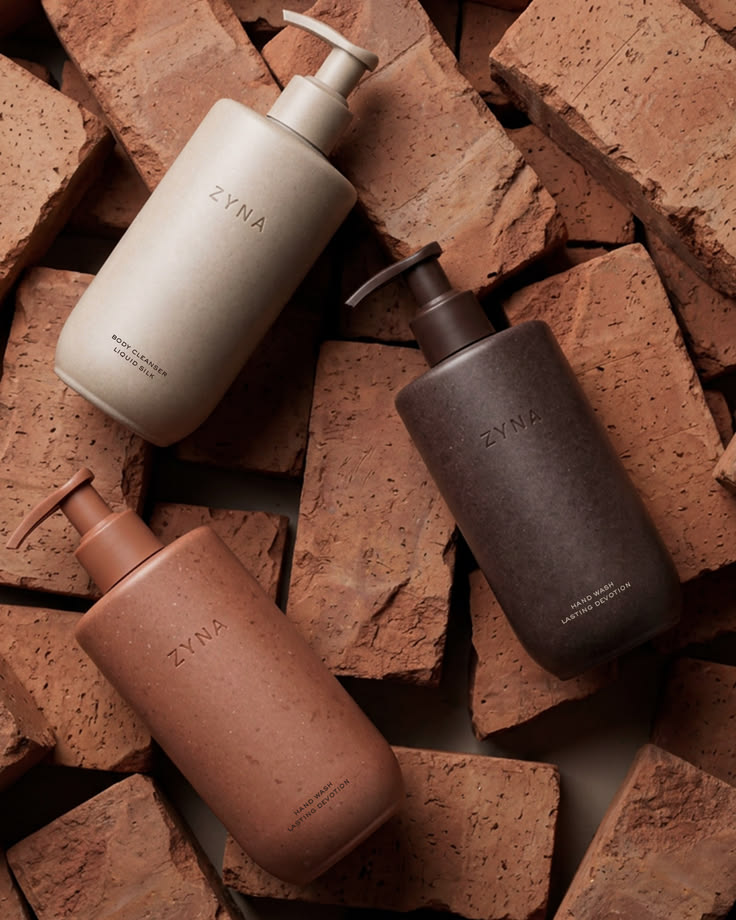 Copper-toned stoneware bottles standing on a brick ledge