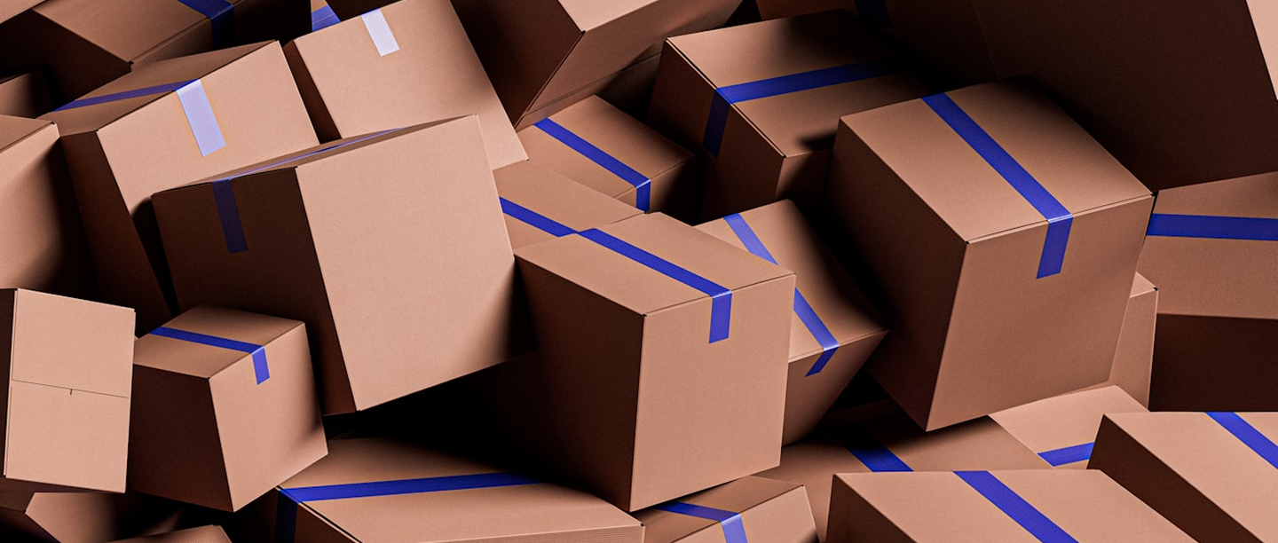 Kraft shipping cartons with blue strapping stacked in shadow