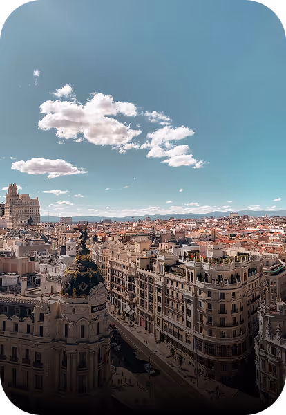 Vue panoramique de Madrid avec des bâtiments historiques sous un ciel bleu partiellement nuageux.