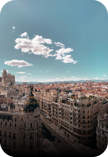 Vue panoramique de Madrid avec des bâtiments historiques sous un ciel bleu partiellement nuageux.