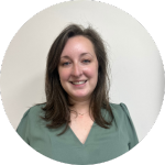 Smiling woman with shoulder-length brown hair wearing a green top against a plain light background.