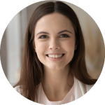 Smiling woman with long brown hair in a softly lit indoor setting.