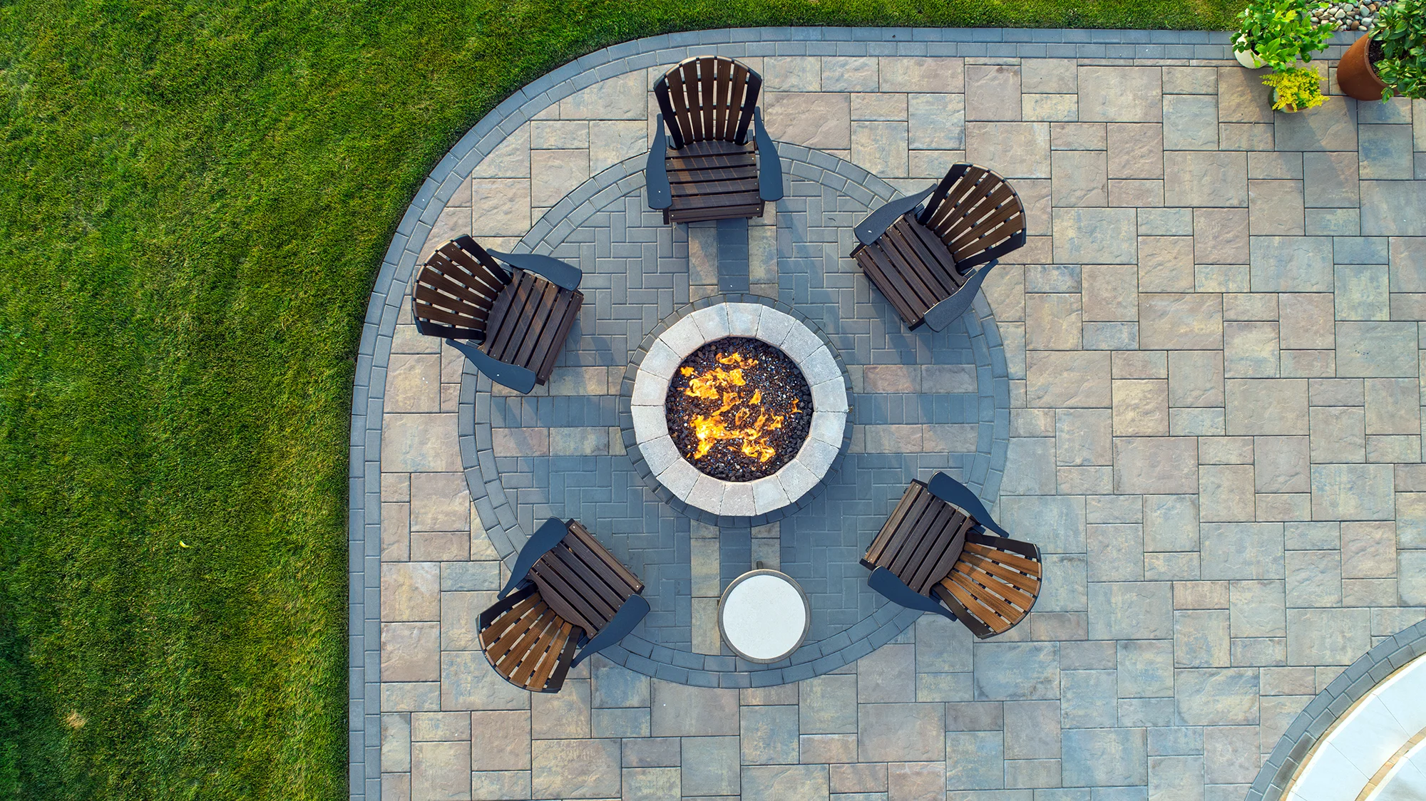 Custom paver patio fire pit detail showing circular layout, contrasting border pattern, and refined hardscape finish