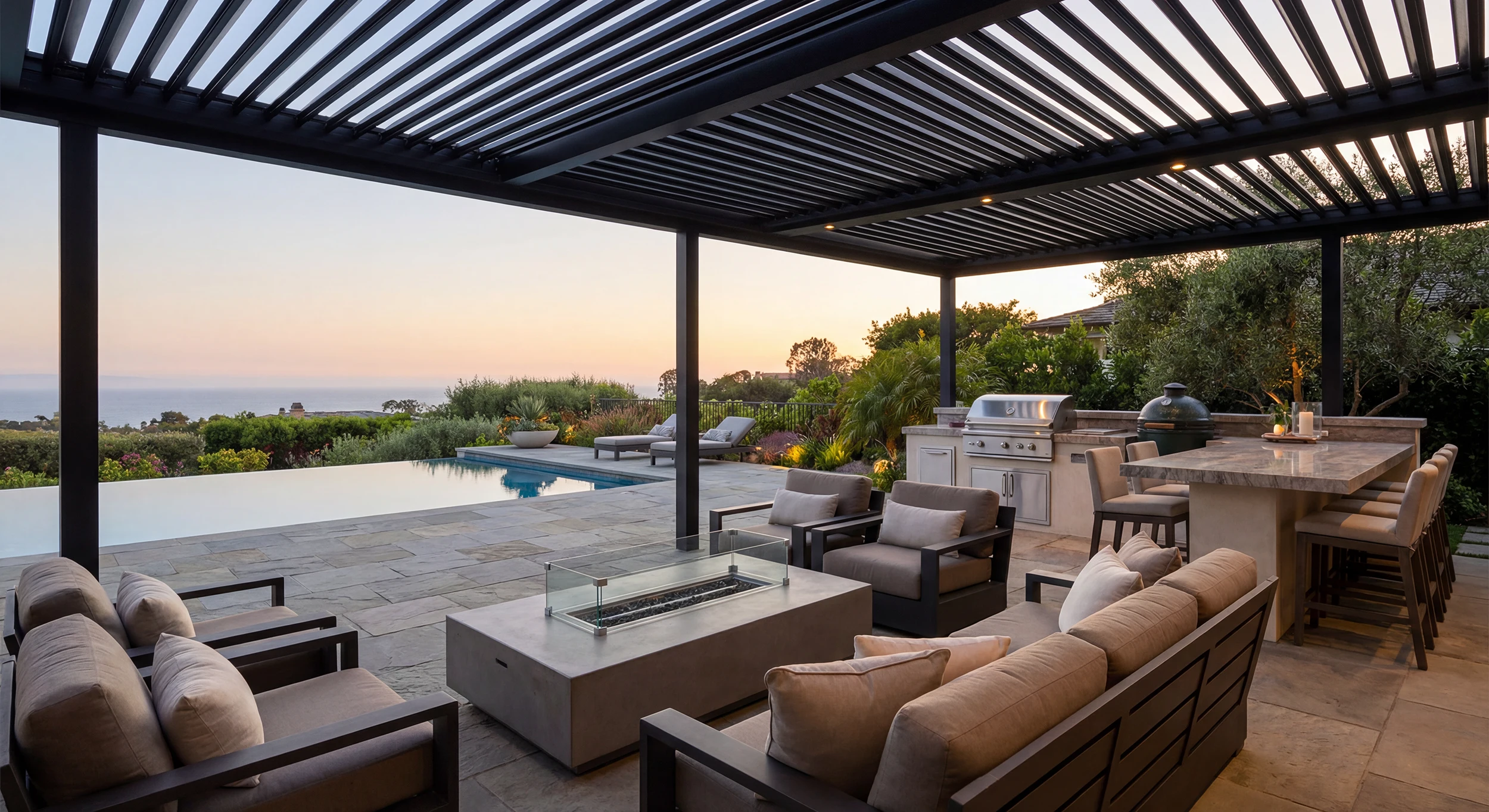 Motorized pergola with outdoor kitchen, fire feature, and poolside seating in a complete outdoor living installation in South Carolina