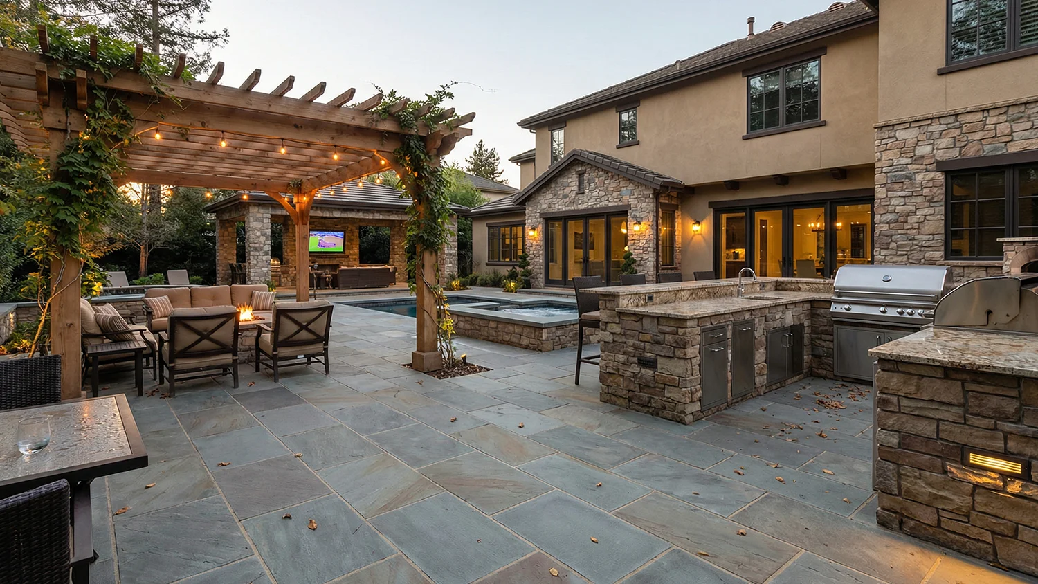 Complete outdoor living space with pergola seating area, outdoor kitchen, fire feature, and pool in a multi-zone backyard design