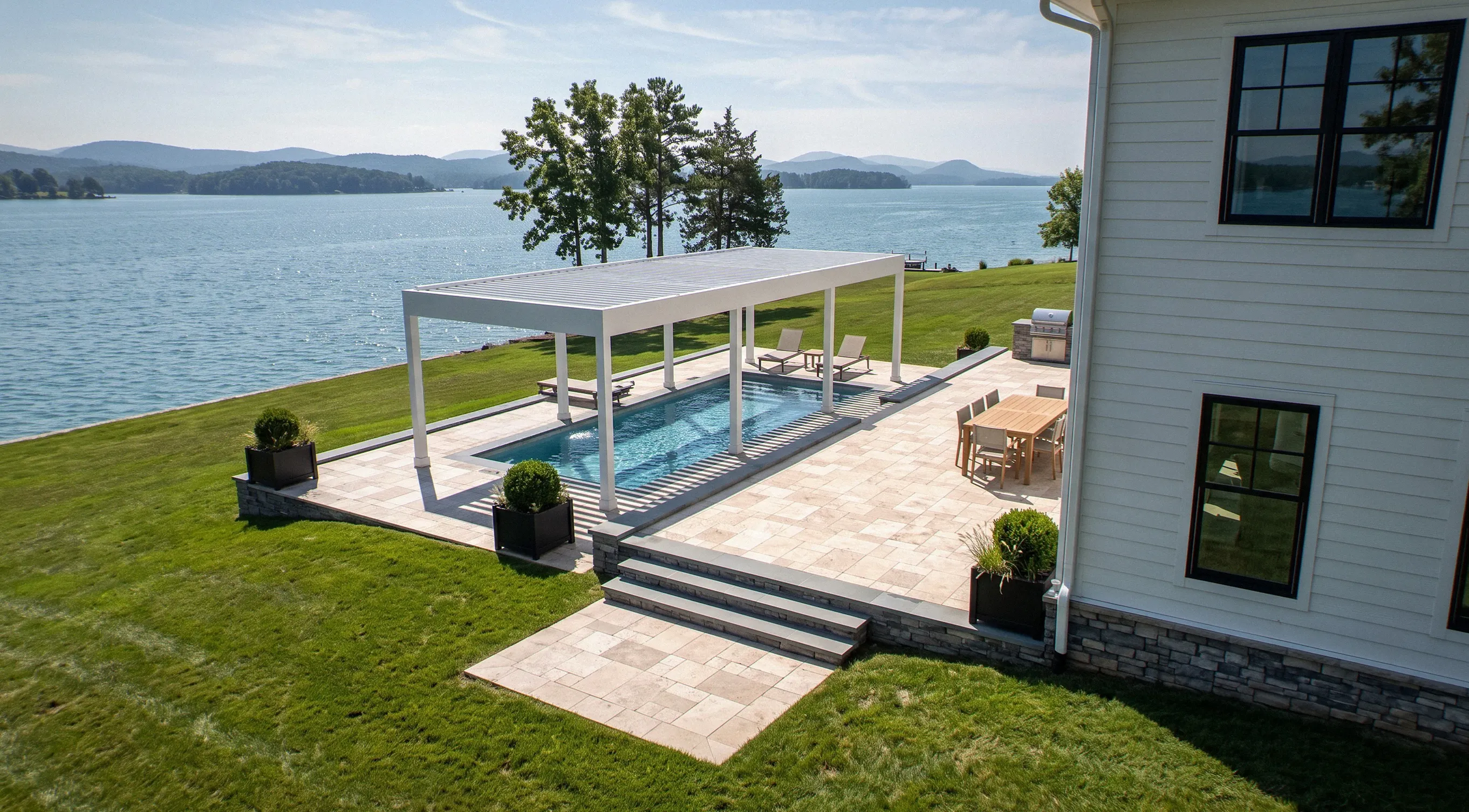 White motorized louvered pergola over a lakefront swim spa on a multilevel travertine terrace at Smith Mountain Lake, VA — Allscape Patio