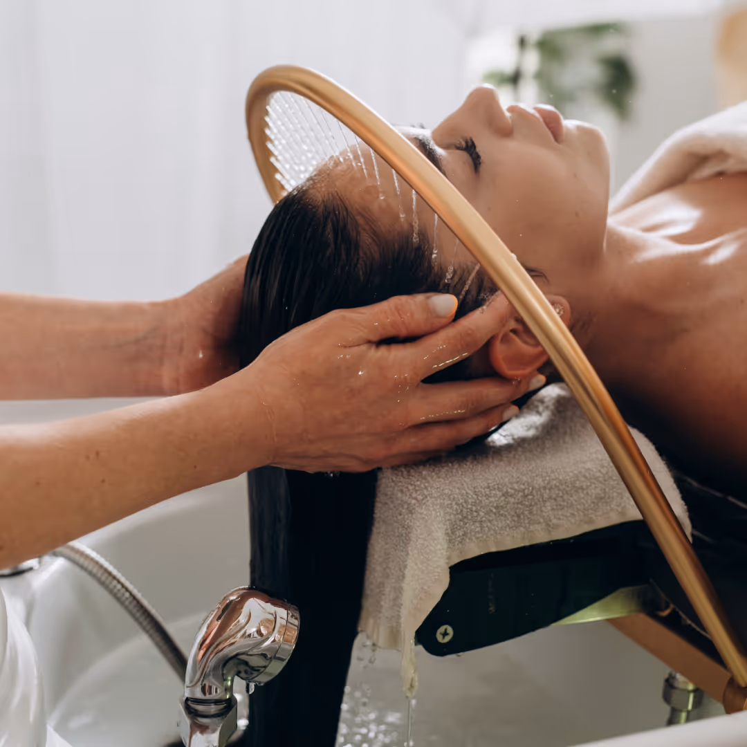 water from a golden halo rinsing a woman's hair