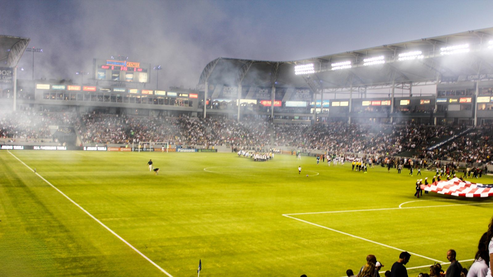 European football stadium under floodlights before kickoff, tense atmosphere during a domestic cup match with packed stands and visible match preparations.