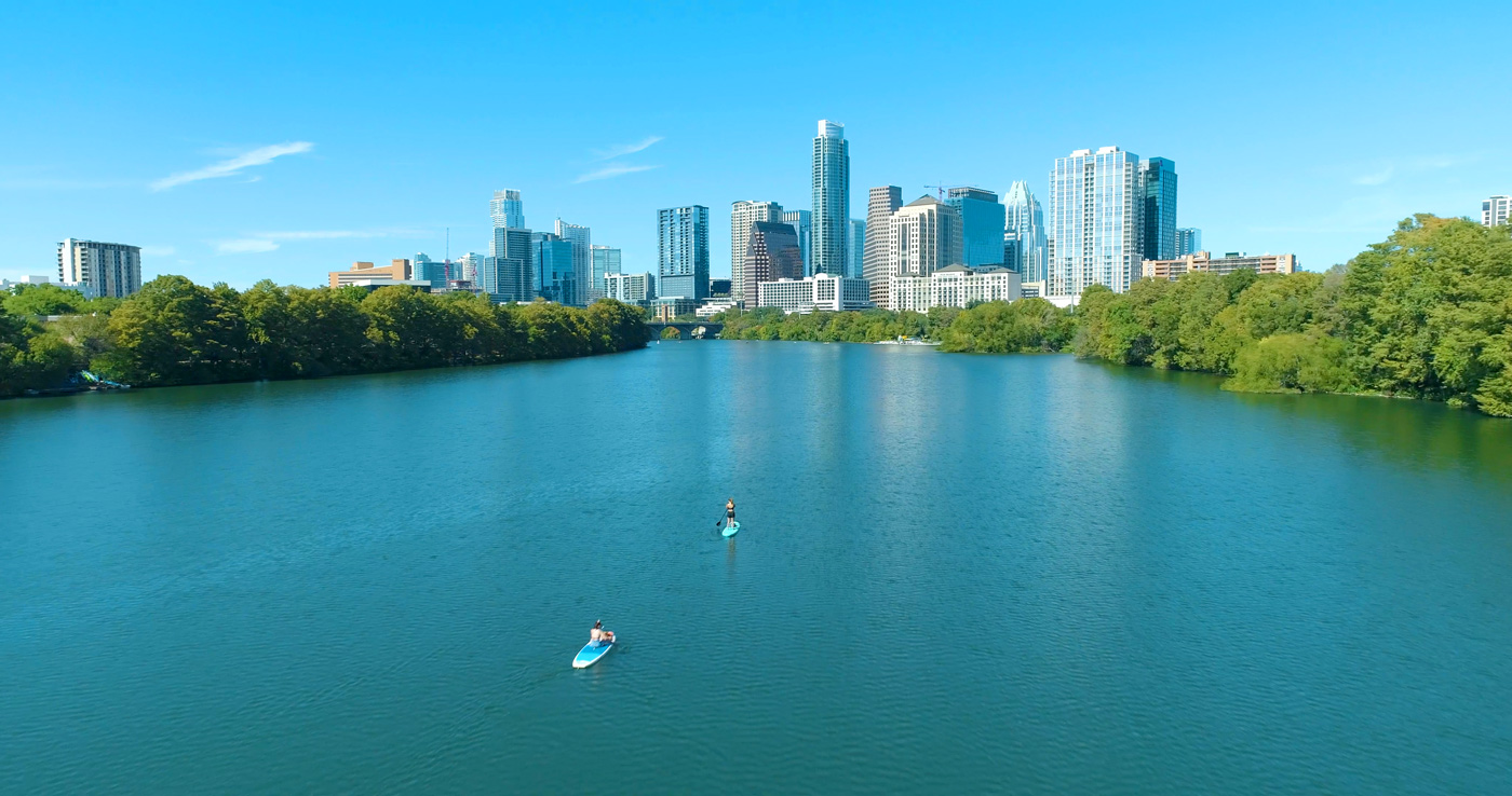 Lake Austin Colorado River in Austin photo by drone with kayakers and standup paddleboarders with view of downtown skyline