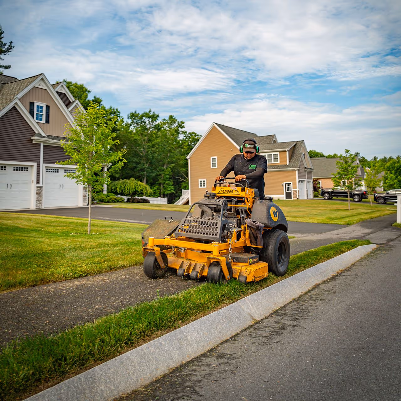 Lawn care crew mowing a residential property by OFlaherty Lawn Care in Attleboro Massachusetts near me