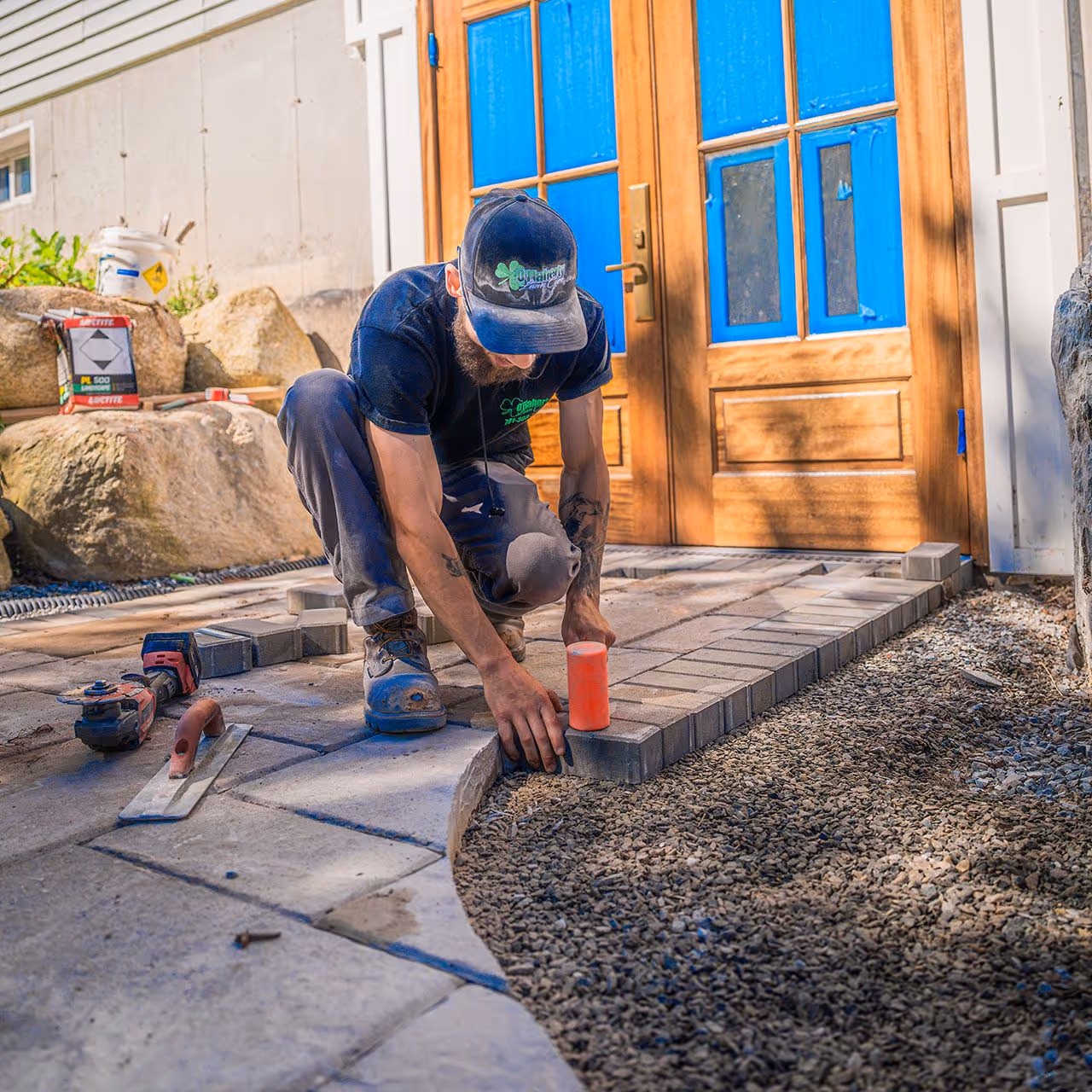 Crew installing a custom paver patio by OFlaherty Lawn Care in Attleboro Massachusetts near me