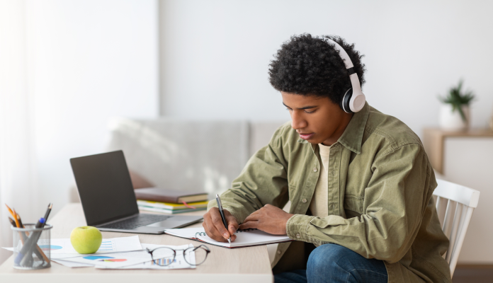 Man studying with headphones on stock image