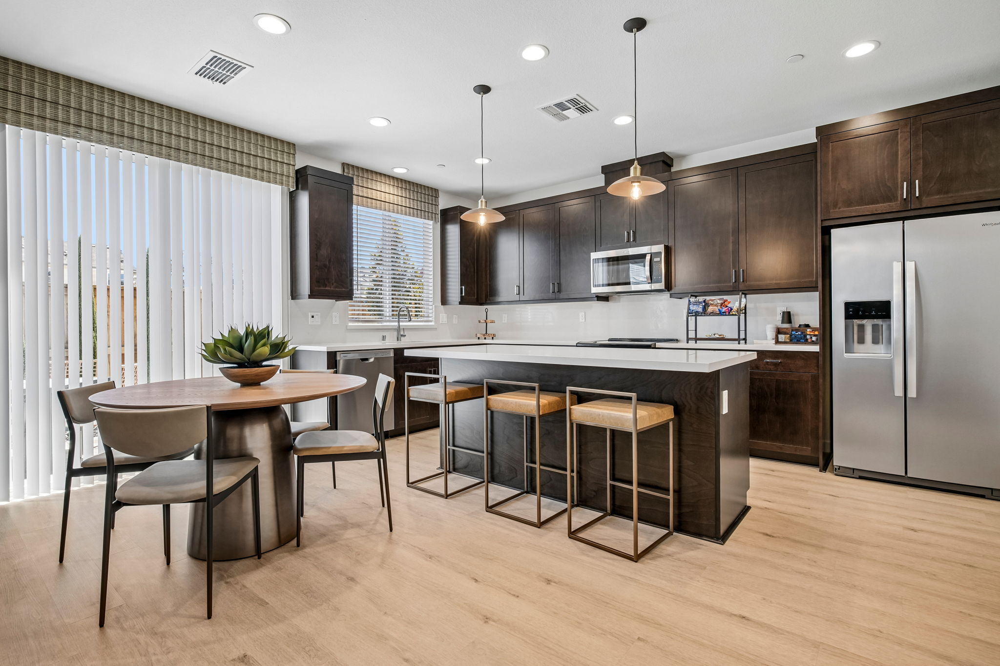 Dining area with table and chairs and Kitchen with island, brown cabinets and stainless steel appliances