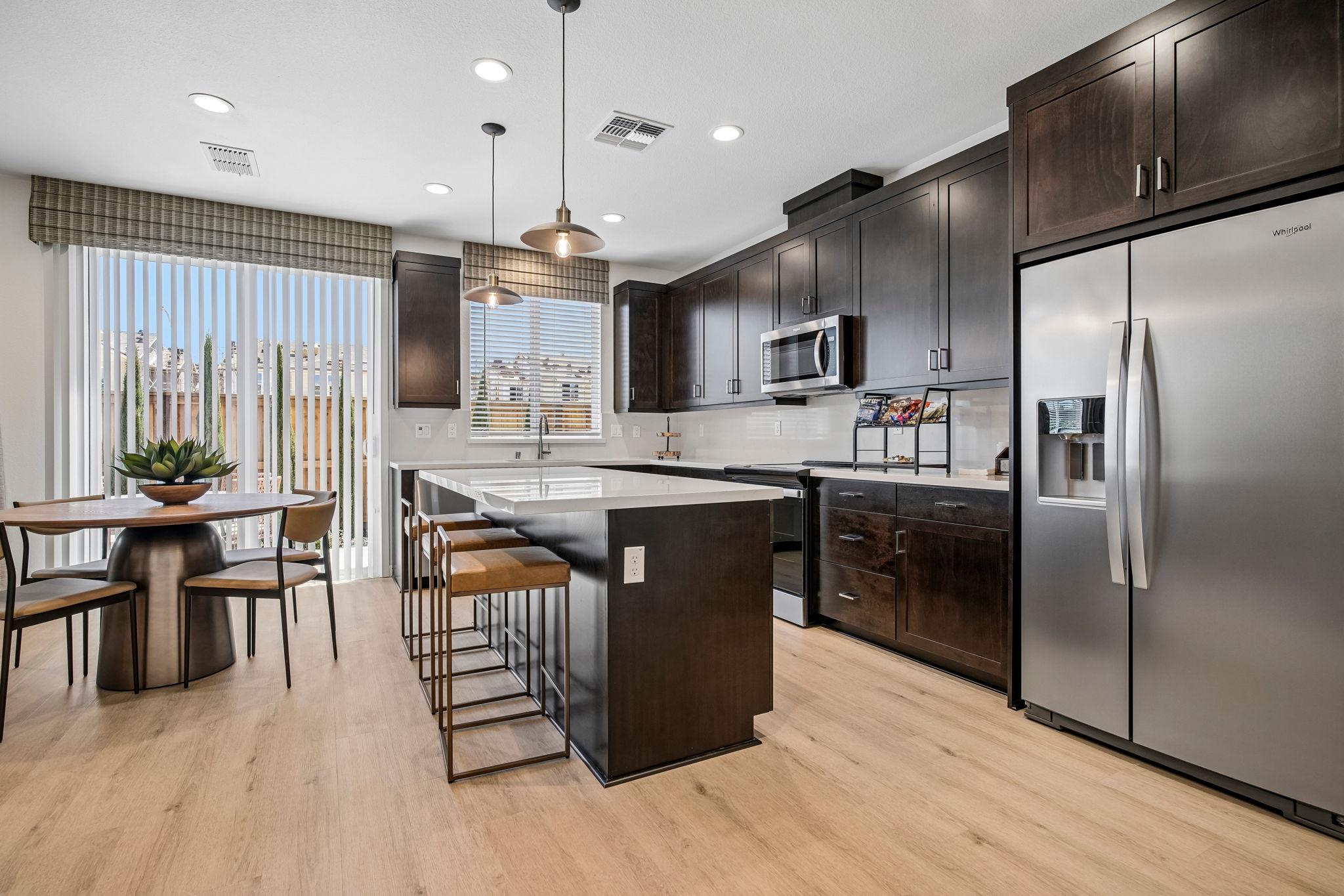Dining area with table and chairs and Kitchen with island, brown cabinets and stainless steel appliances