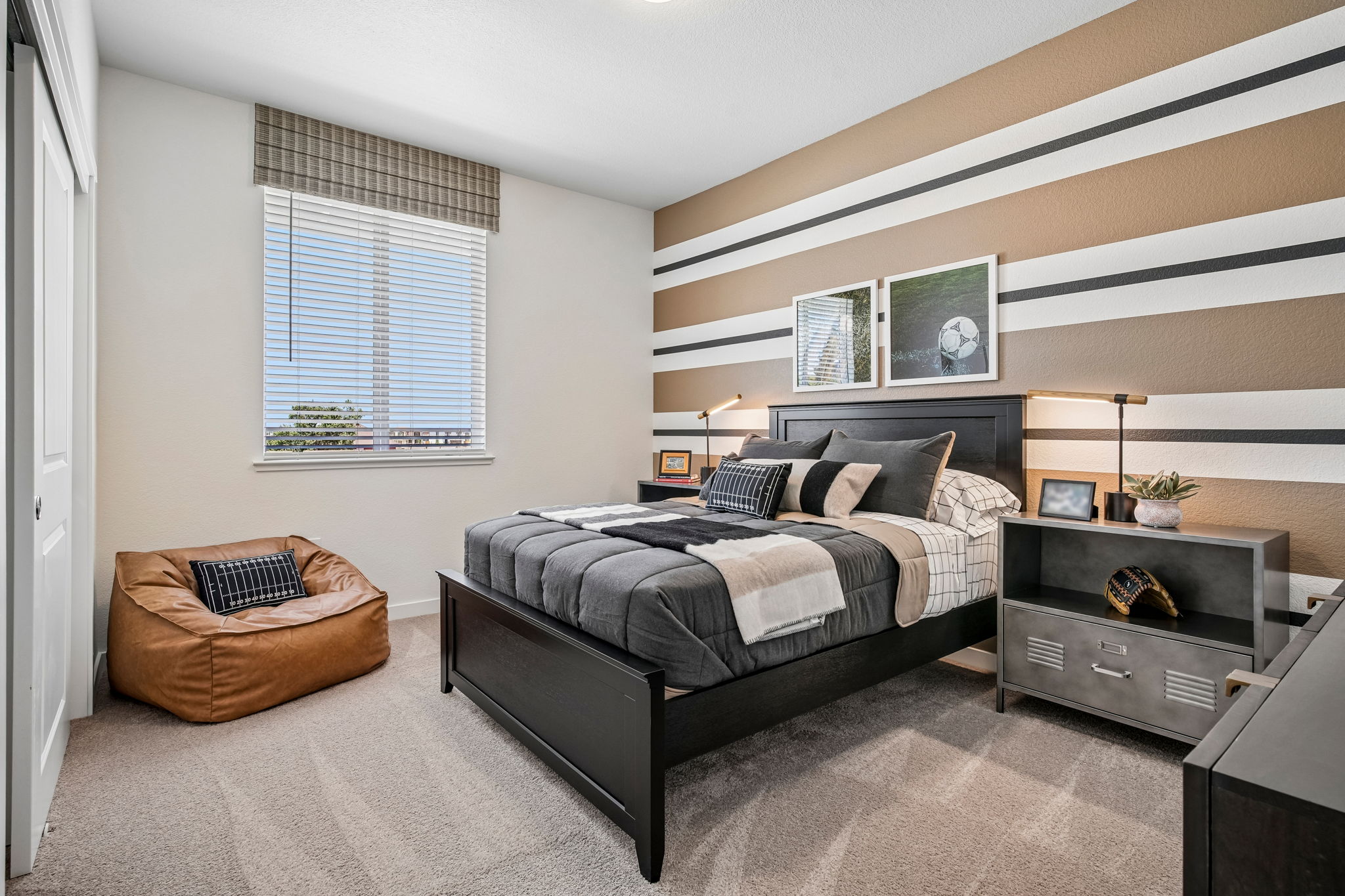 Bedroom with bed, large window, chair and table with lamp