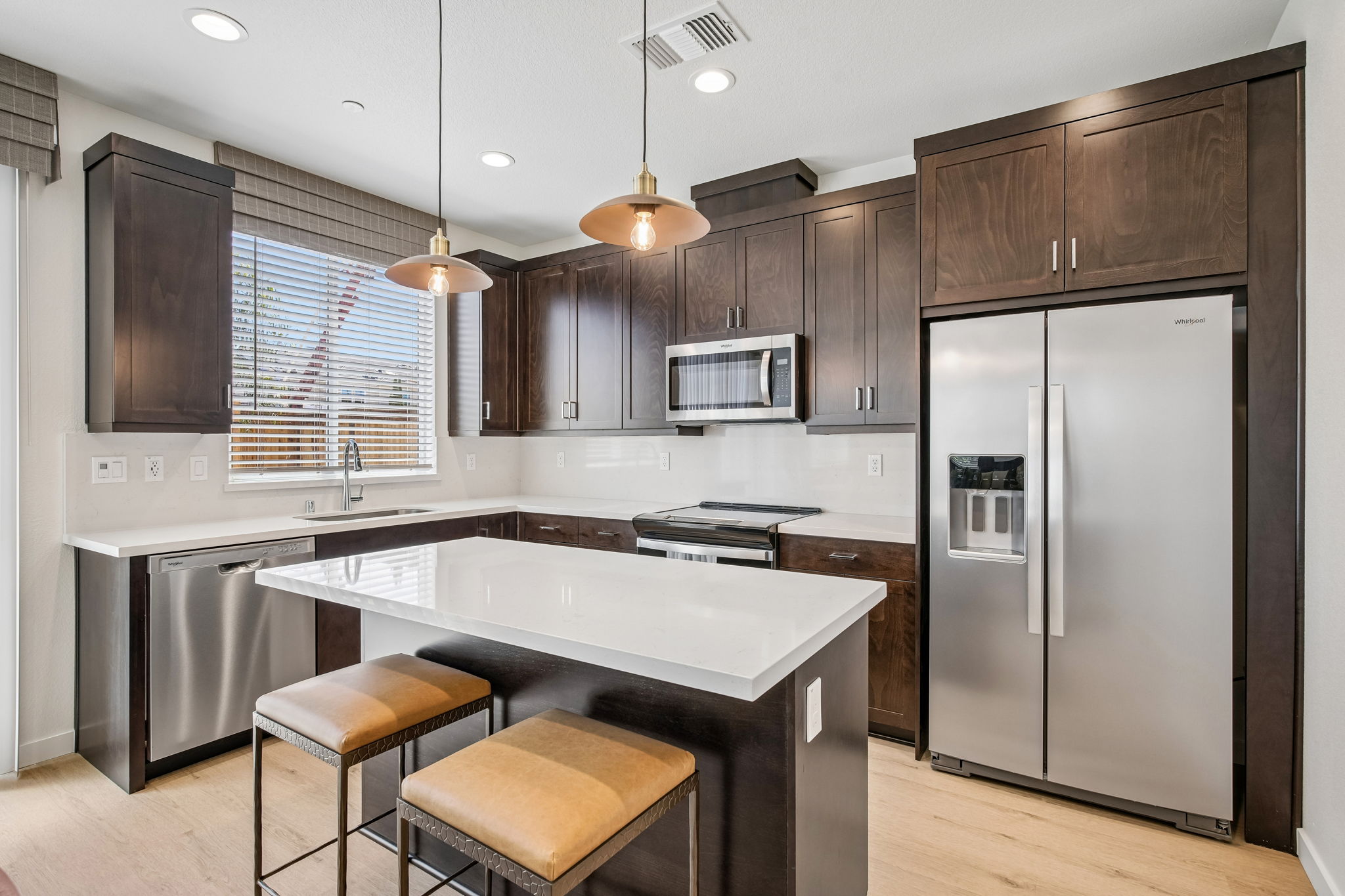 Kitchen with island, brown cabinets and stainless steel appliances